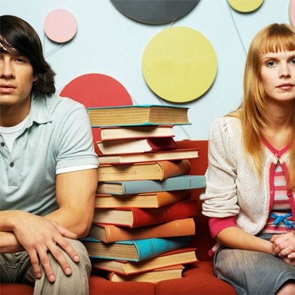 picture of couple between a pile of book to study for english exams